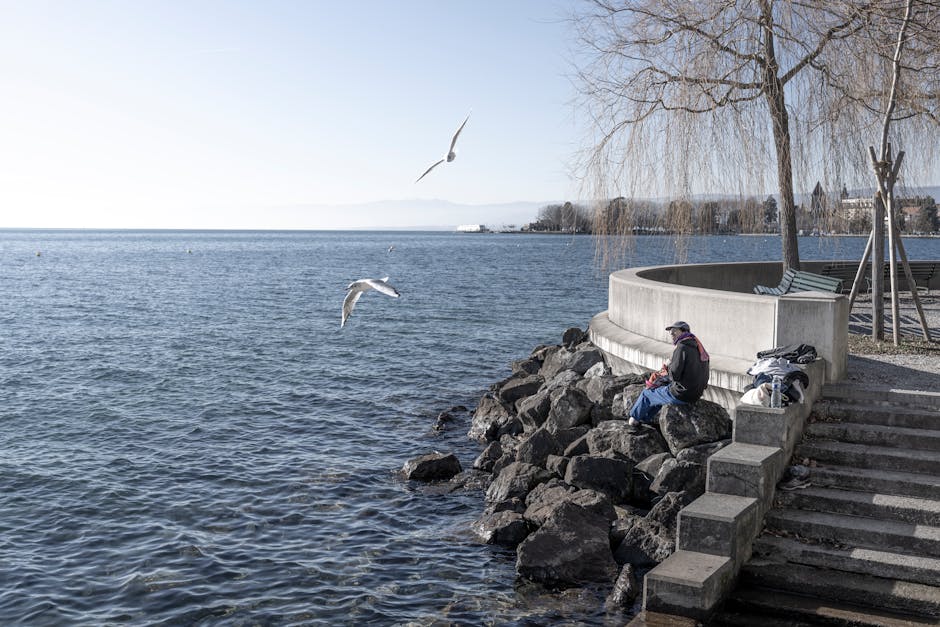 A peaceful scene of a man fishing by Lak